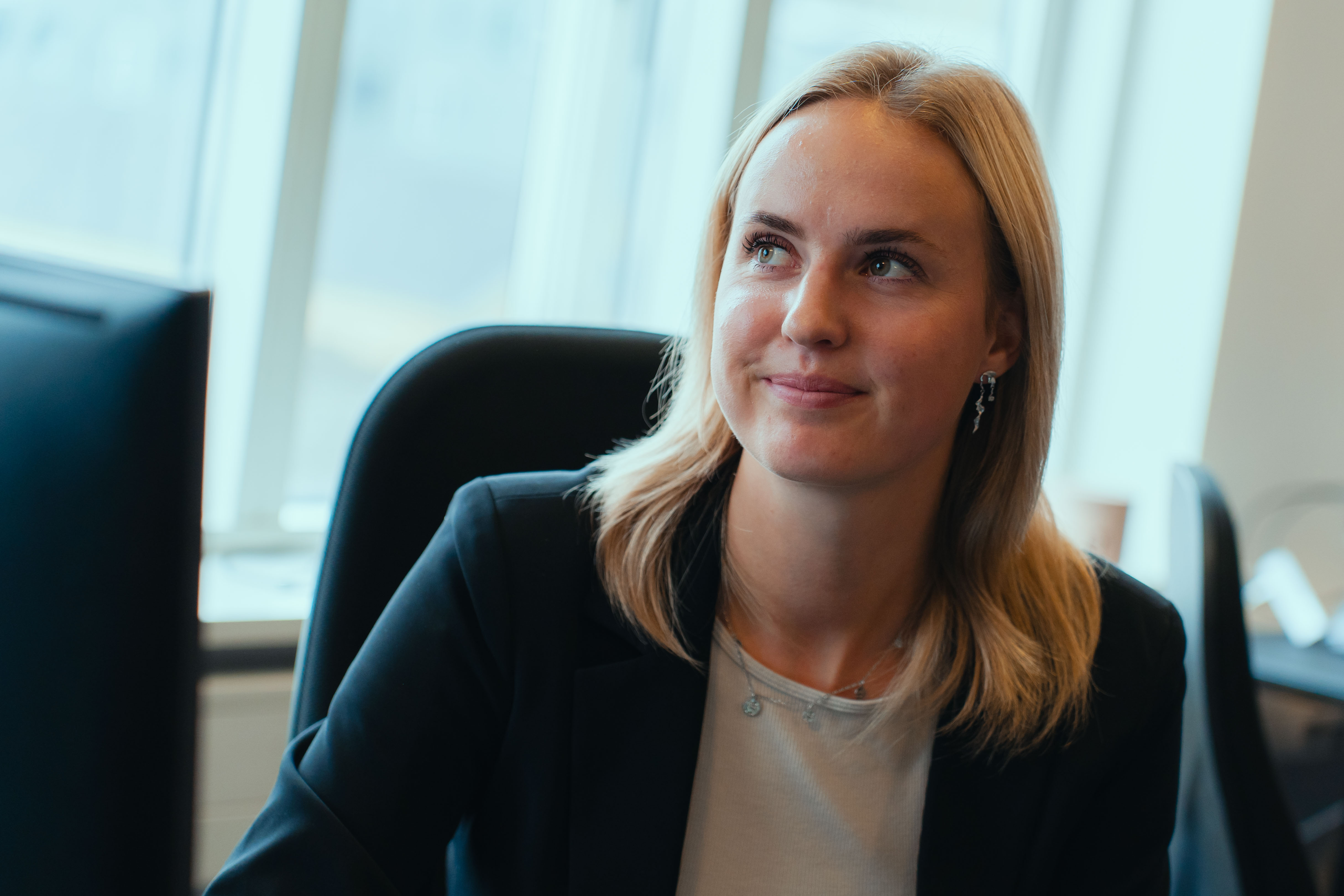 Camilla Amorsen smiler og kigger opad i et kontorlokale